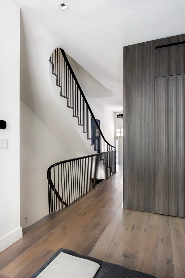 a view of staircase with wooden floor and a rug