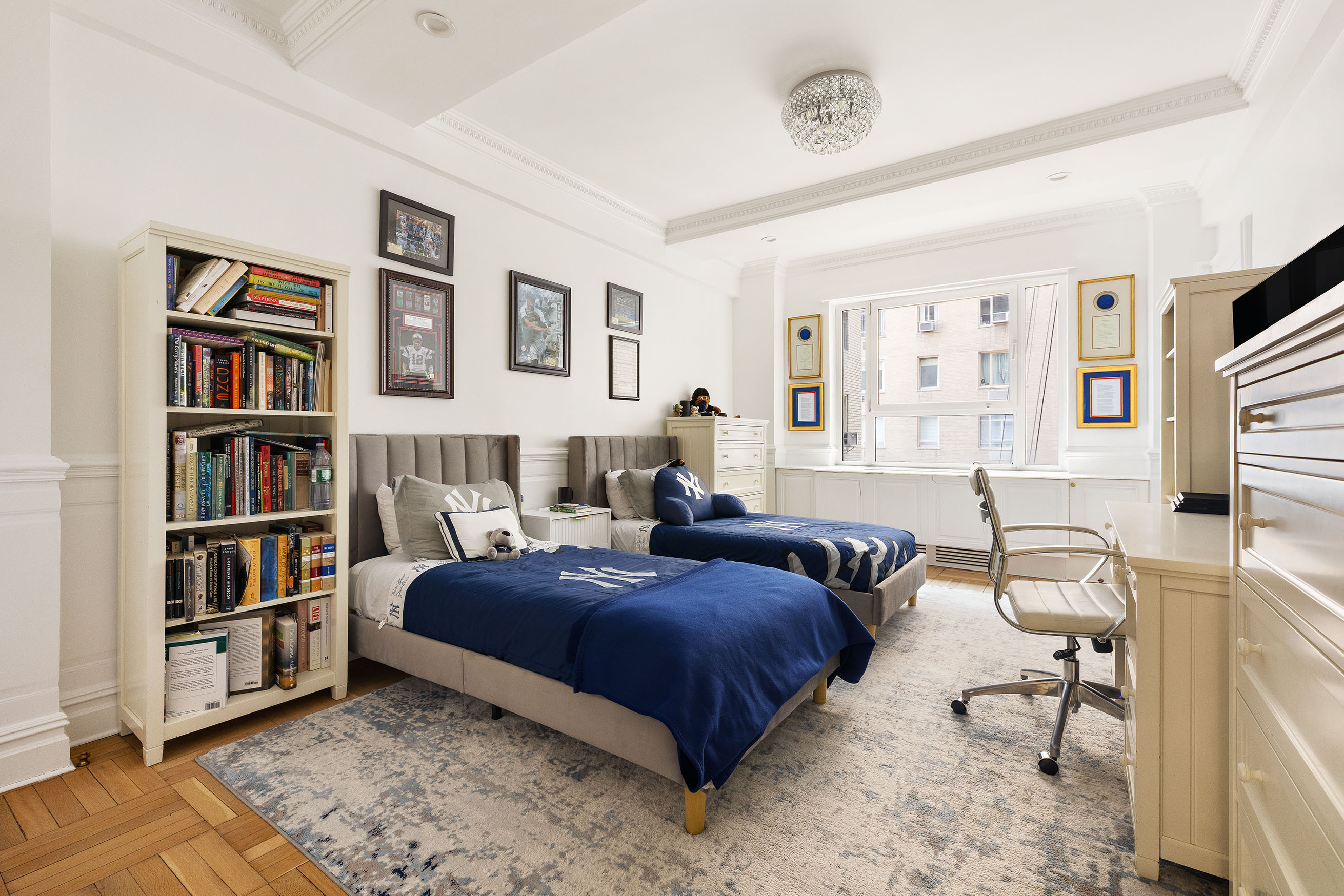 875 5th Avenue, Unit 8D Manhattan, NY 10065 - Photo 10 of 13 a bedroom with a bed furniture and a book shelf