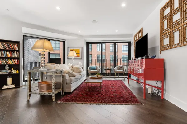 a living room with furniture hard wood floor and a flat screen tv