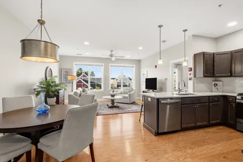 a large kitchen with sink a counter and chairs