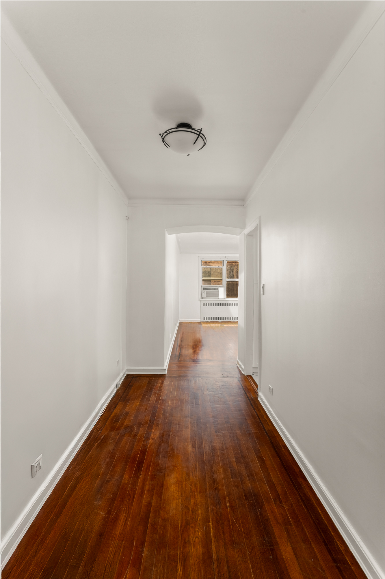 310 West 55th Street, Unit 4K Manhattan, NY 10019 - Photo 5 of 9 wooden floor in an empty room with a window