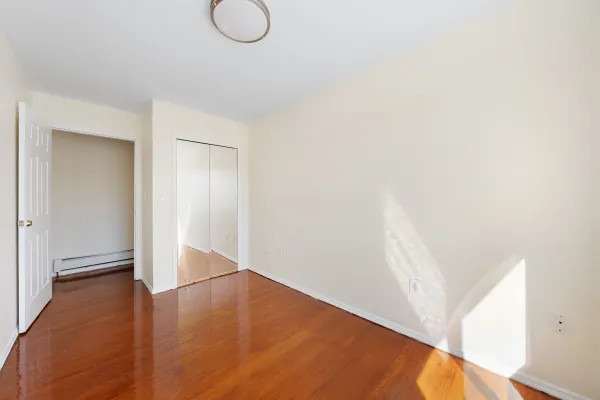 a view of a room with wooden floor and white walls