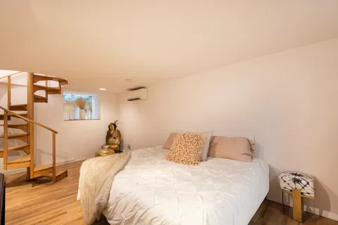 a bedroom with a bed and wooden floor