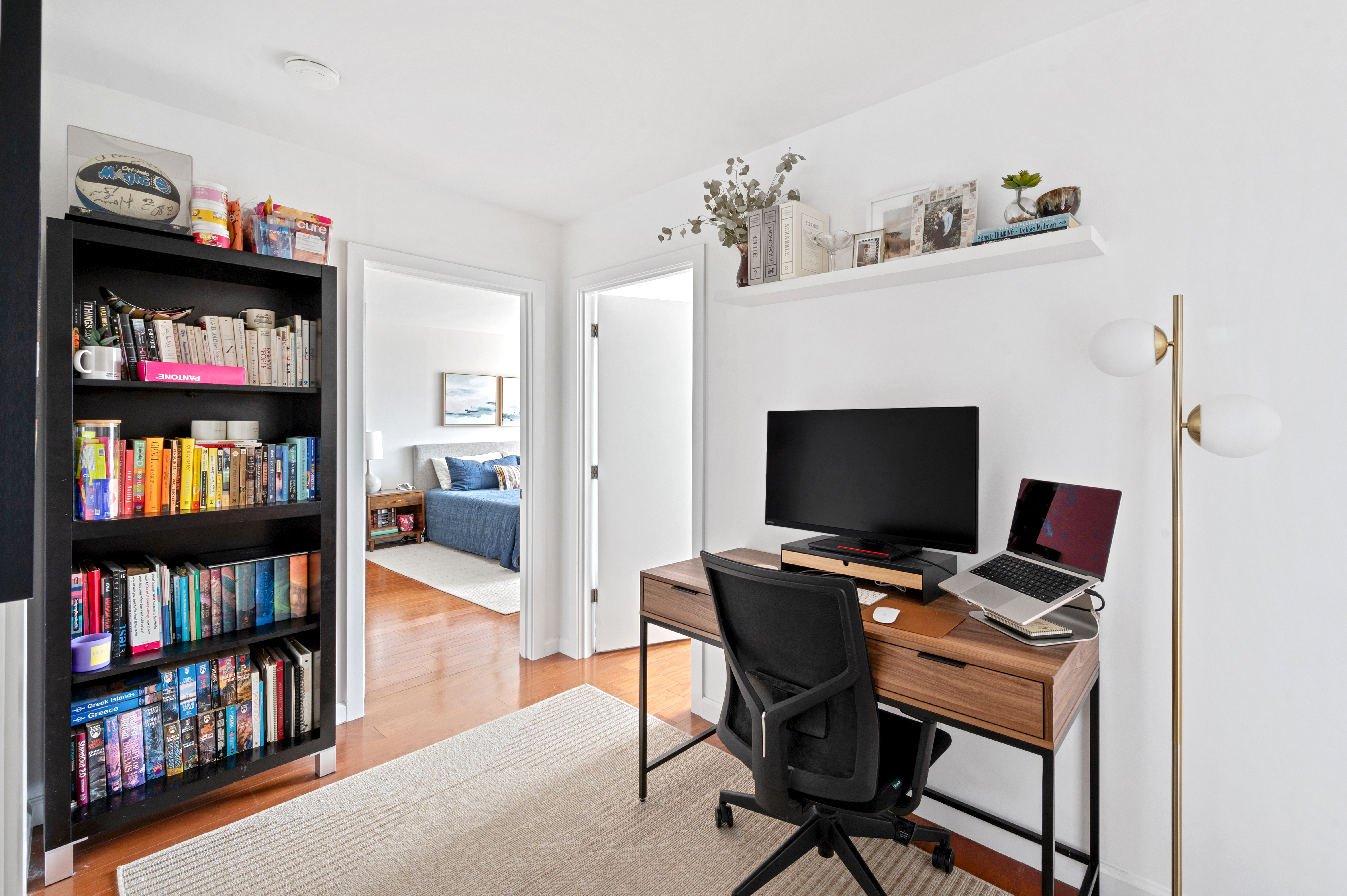 245 East 54th Street, Unit 26JK Manhattan, NY 10022 - Photo 5 of 12 a view of a workspace with furniture and a bookshelf