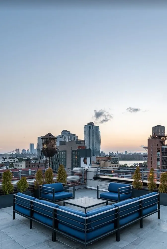 a roof deck with outdoor seating and city view