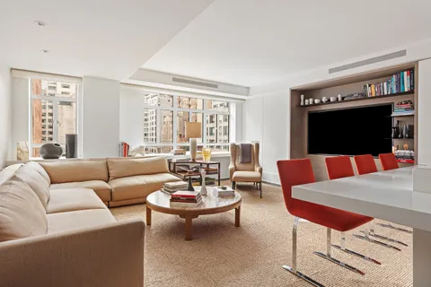 a living room with furniture a rug and a flat screen tv