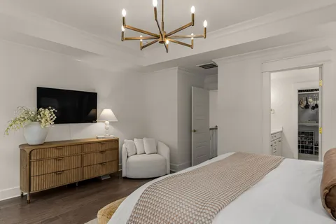 a bedroom with a bed window and a flat screen tv