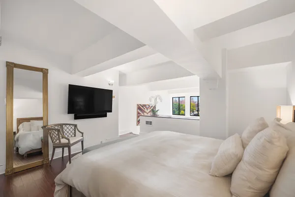 a bedroom with furniture and a flat screen tv