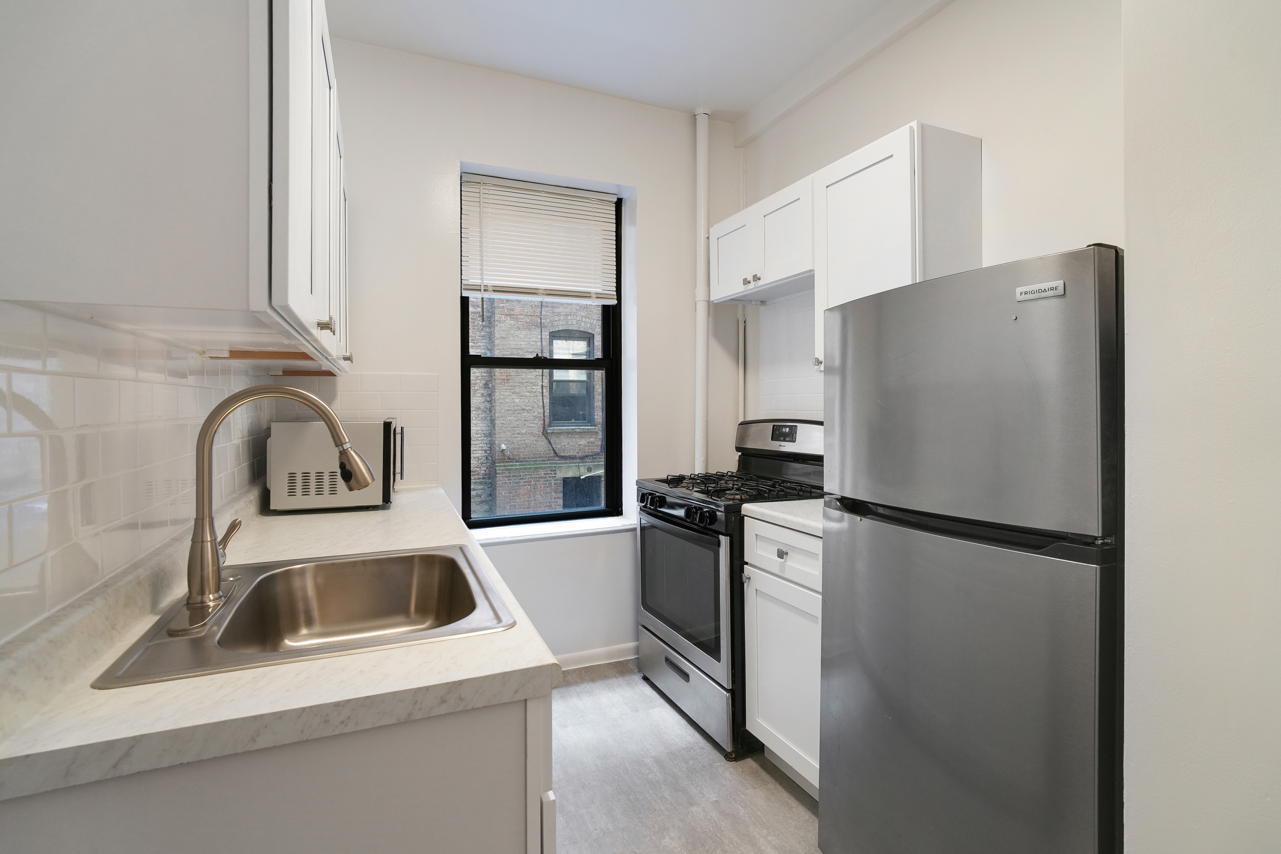 507 West 111th Street, Unit 3 Manhattan, NY 10025 - Photo 4 of 11 a kitchen with a refrigerator sink and stove