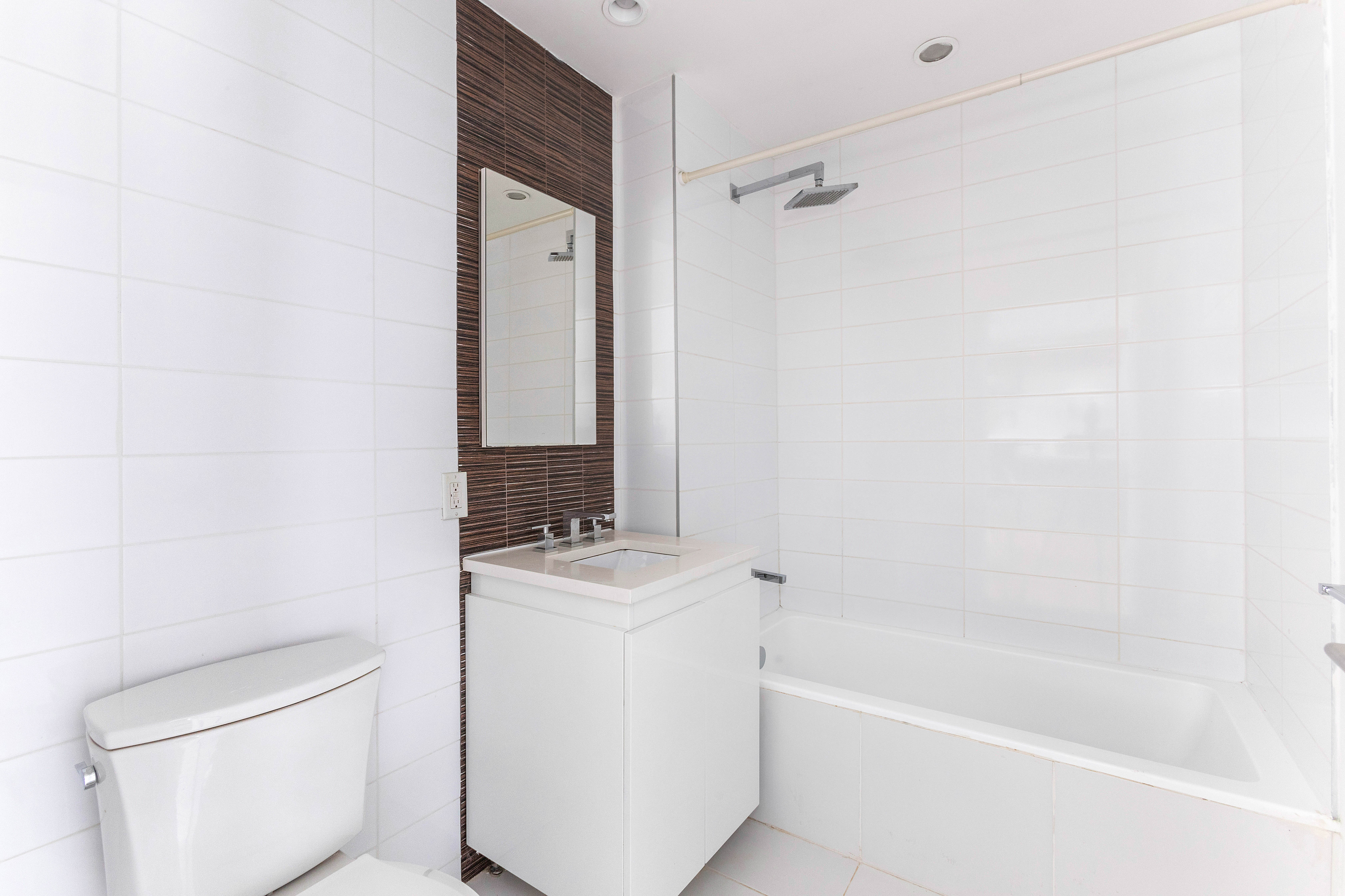 267 6th Street, Unit 5J Brooklyn, NY 11215 - Photo 4 of 14 a bathroom with a granite countertop sink a toilet and bathtub