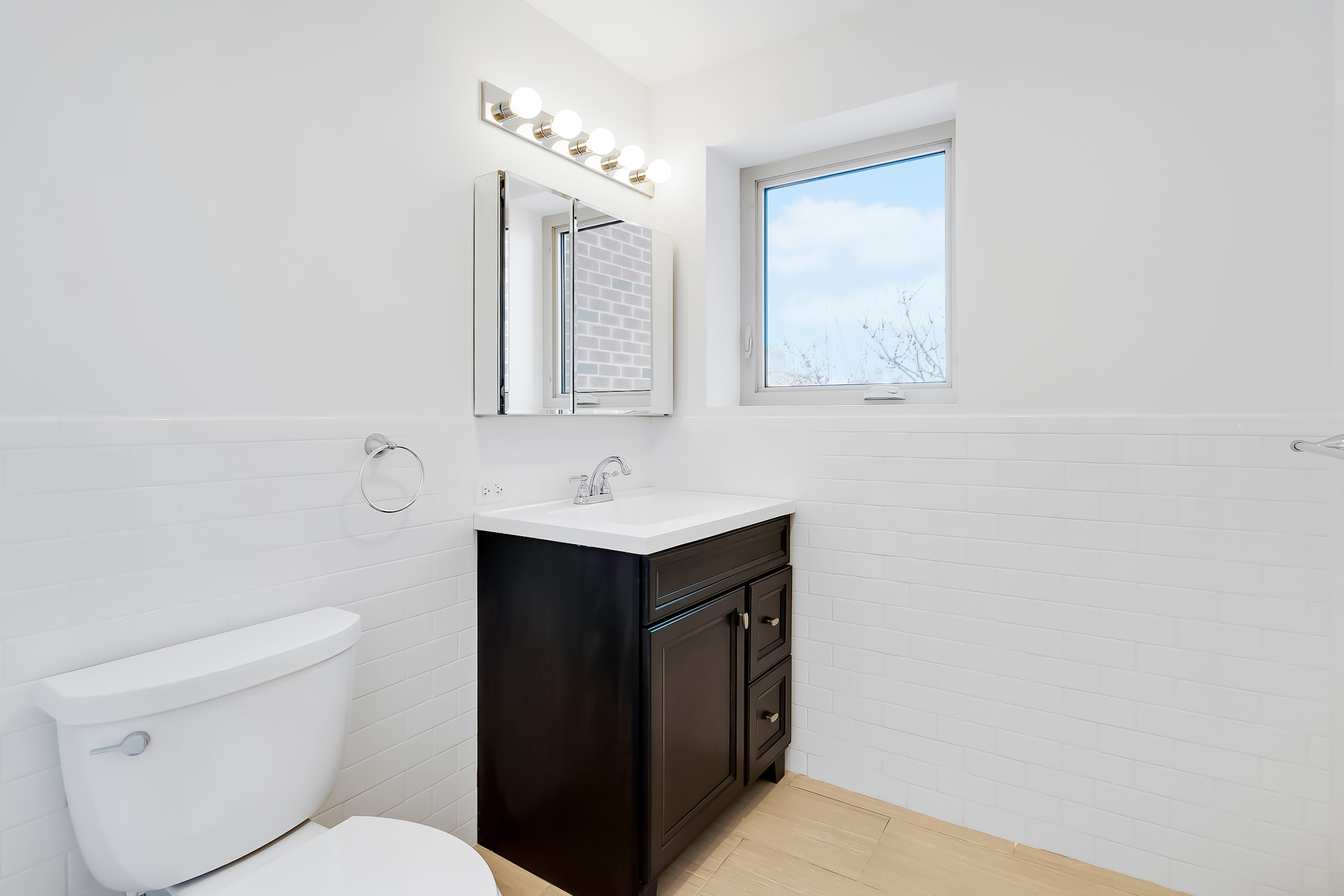 26-20 14th Place, Unit 3D Queens, NY 11102 - Photo 7 of 12 a bathroom with a toilet sink vanity and mirror