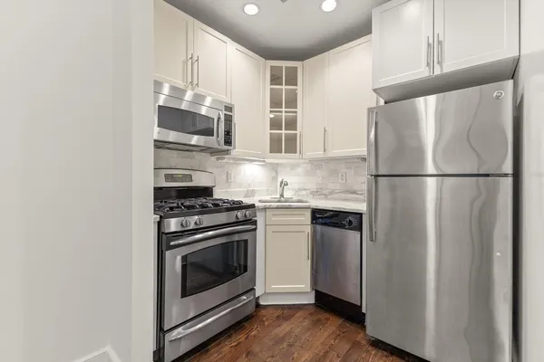 a kitchen with stainless steel appliances granite countertop a refrigerator sink and stove