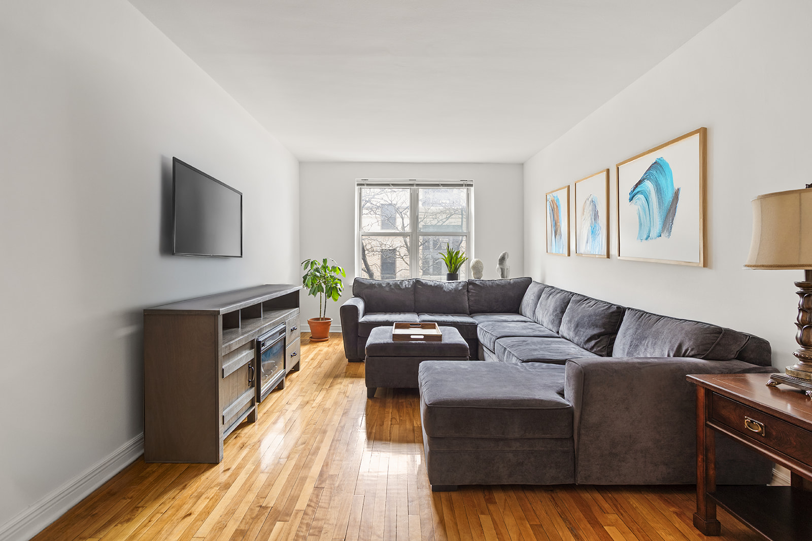 33-16 82nd Street, Unit 4C Queens, NY 11372 - Photo 1 of 13 a living room with furniture and a flat screen tv