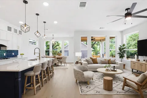 a living room with lots of white furniture and a large window