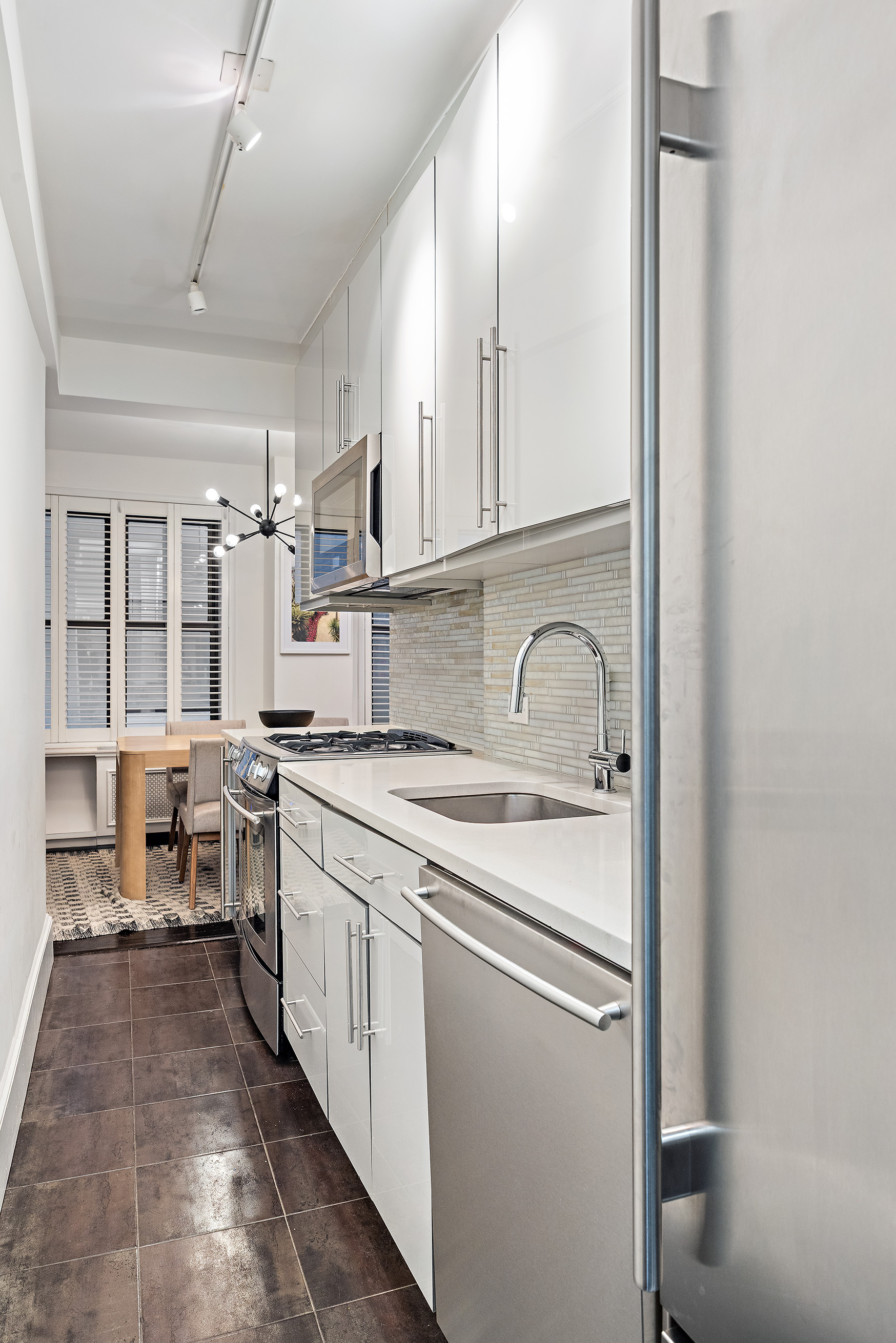 325 East 79th Street, Unit 6C Manhattan, NY 10075 - Photo 8 of 17 a kitchen with a sink stove and cabinets