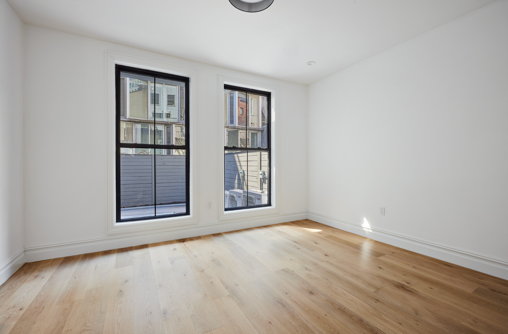 576 Carroll Street, Unit 1 Brooklyn, NY 11215 - Photo 3 of 4 an empty room with wooden floor and windows