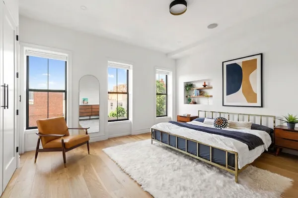 a bedroom with a bed and wooden floor