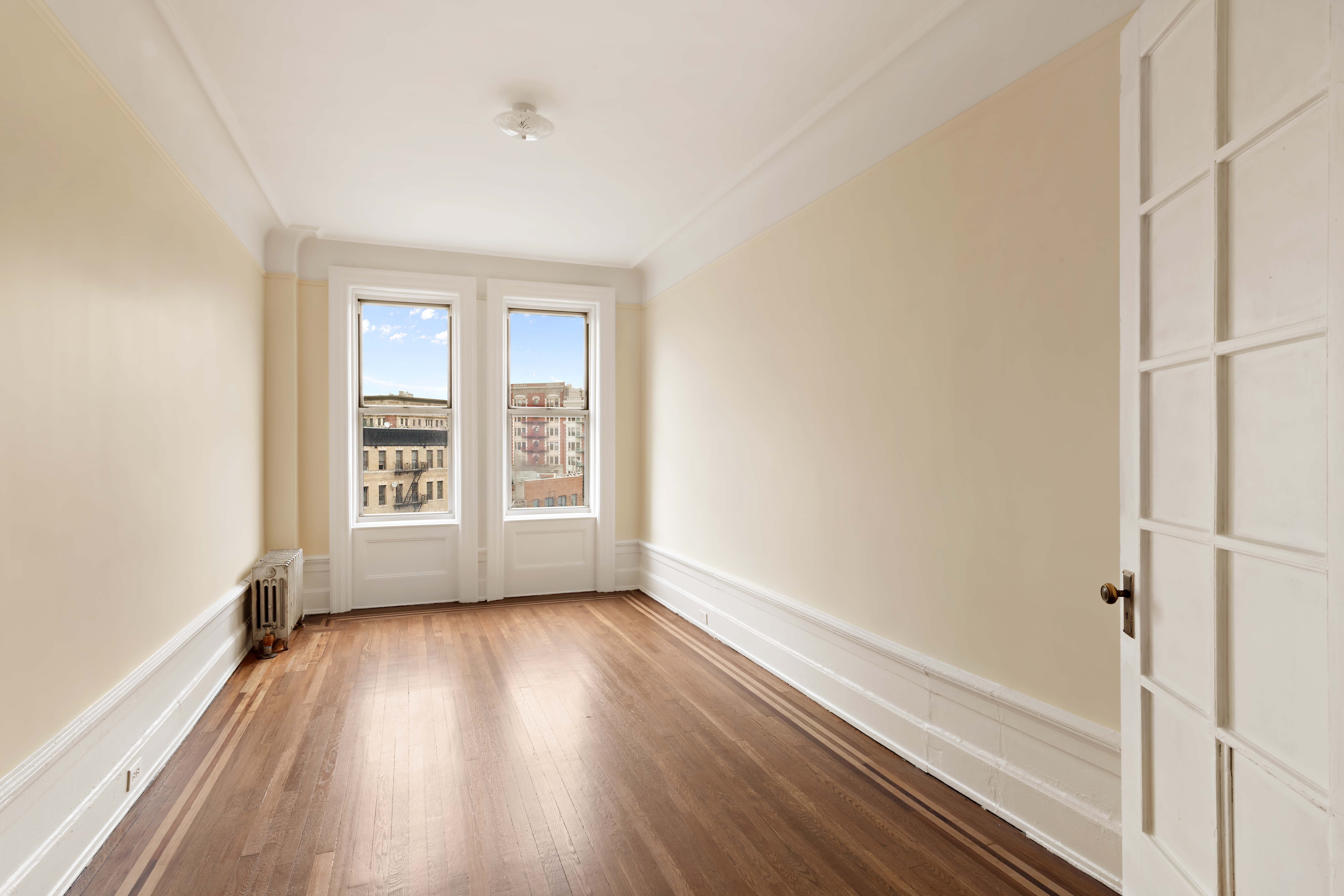 800 Riverside Drive, Unit 6E Manhattan, NY 10032 - Photo 18 of 30 a view of an empty room with a window and wooden floor