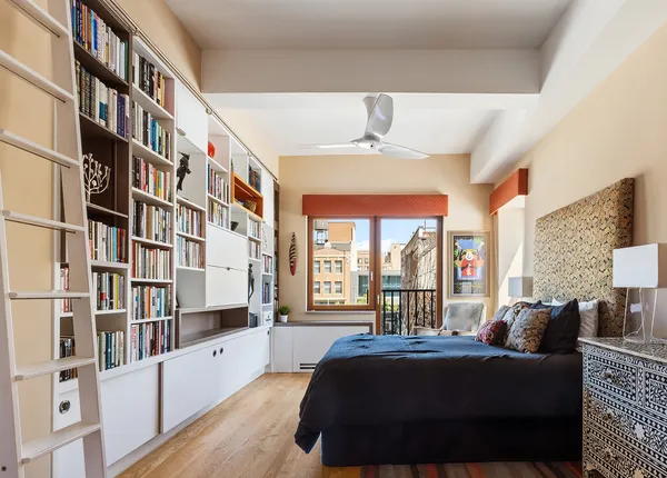 a bedroom with furniture and a large window