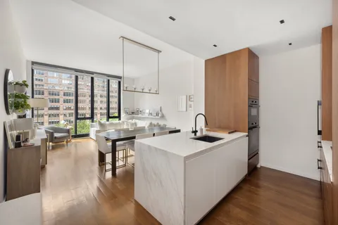 a kitchen with sink and view of living room