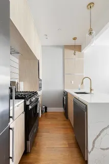 a kitchen with stainless steel appliances granite countertop a sink and stove top oven