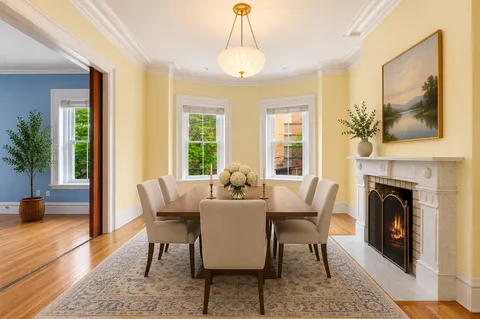 a dining room with furniture a chandelier and wooden floor