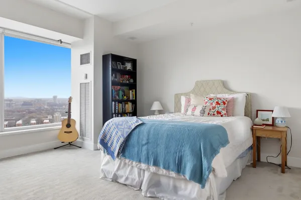 a bedroom with a bed and a large window