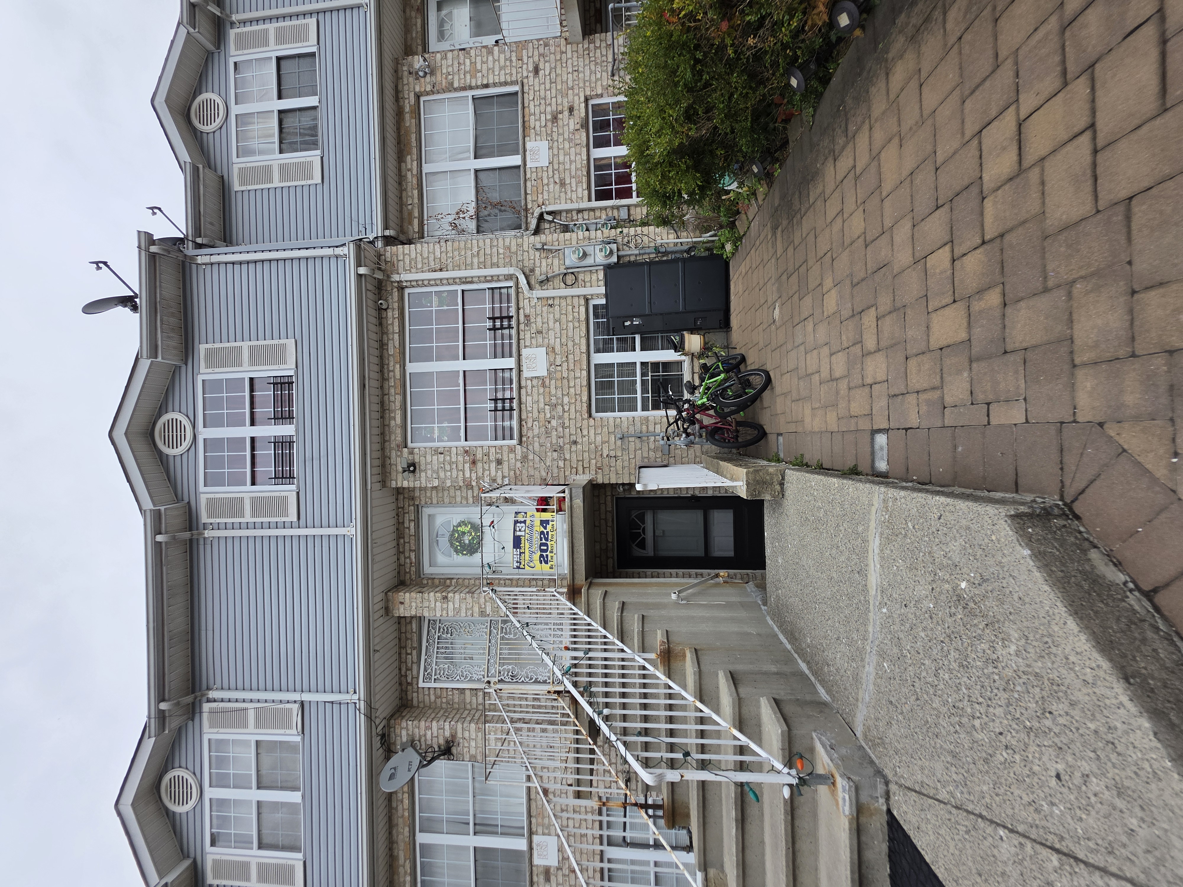 a view of a brick house with many windows and a yard