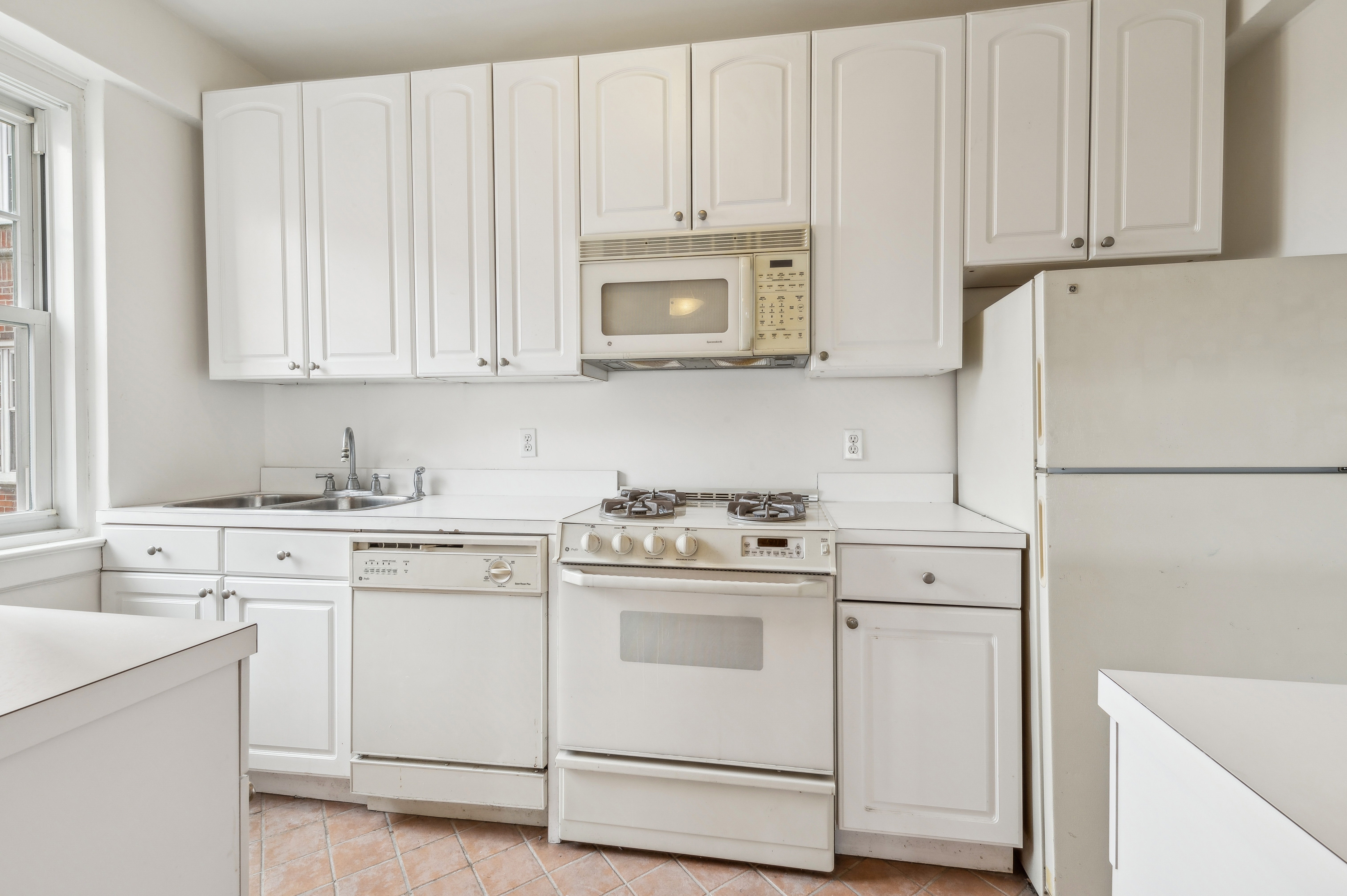 180 Cabrini Boulevard, Unit 98 Manhattan, NY 10033 - Photo 5 of 7 a kitchen with white cabinets and white appliances