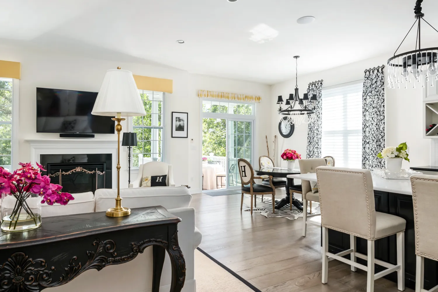 a dining room with wooden floor a chandelier a glass table and chairs