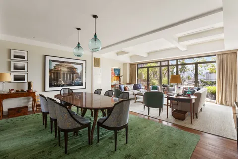 a dining room with furniture a chandelier and wooden floor