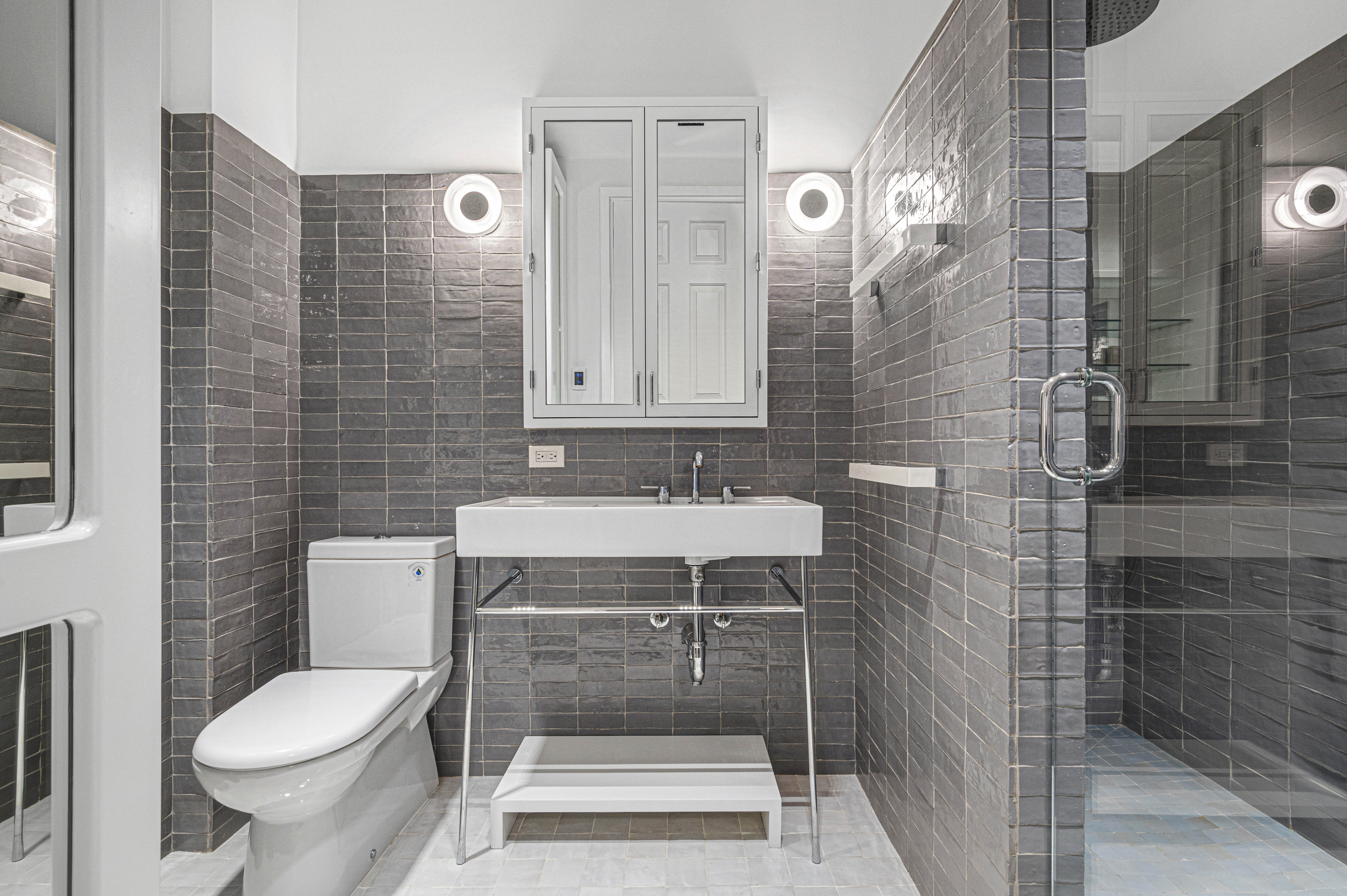 66 Leonard Street, Unit 4E Manhattan, NY 10013 - Photo 5 of 11 a bathroom with a sink toilet and shower