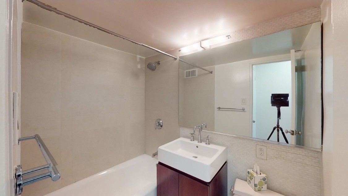 220 East 63rd Street, Unit 4N Manhattan, NY 10065 - Photo 7 of 13 a bathroom with a sink and a mirror