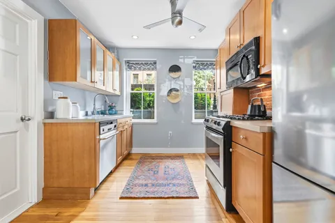 a kitchen with stainless steel appliances granite countertop a refrigerator a stove top oven a sink and dishwasher