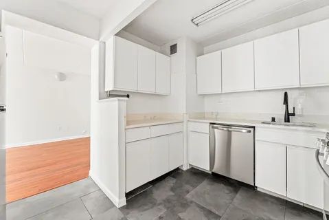a kitchen with white cabinets and white appliances
