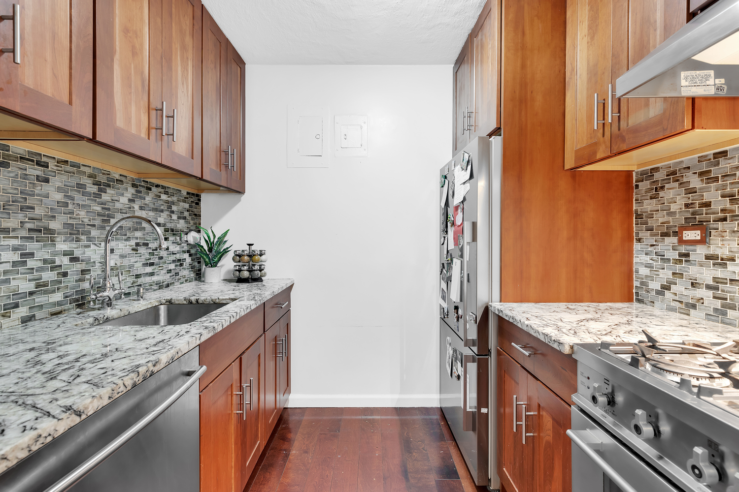 16 West 16th Street, Unit 2LN Manhattan, NY 10011 - Photo 3 of 11 a kitchen with granite countertop cabinets a sink and a stove