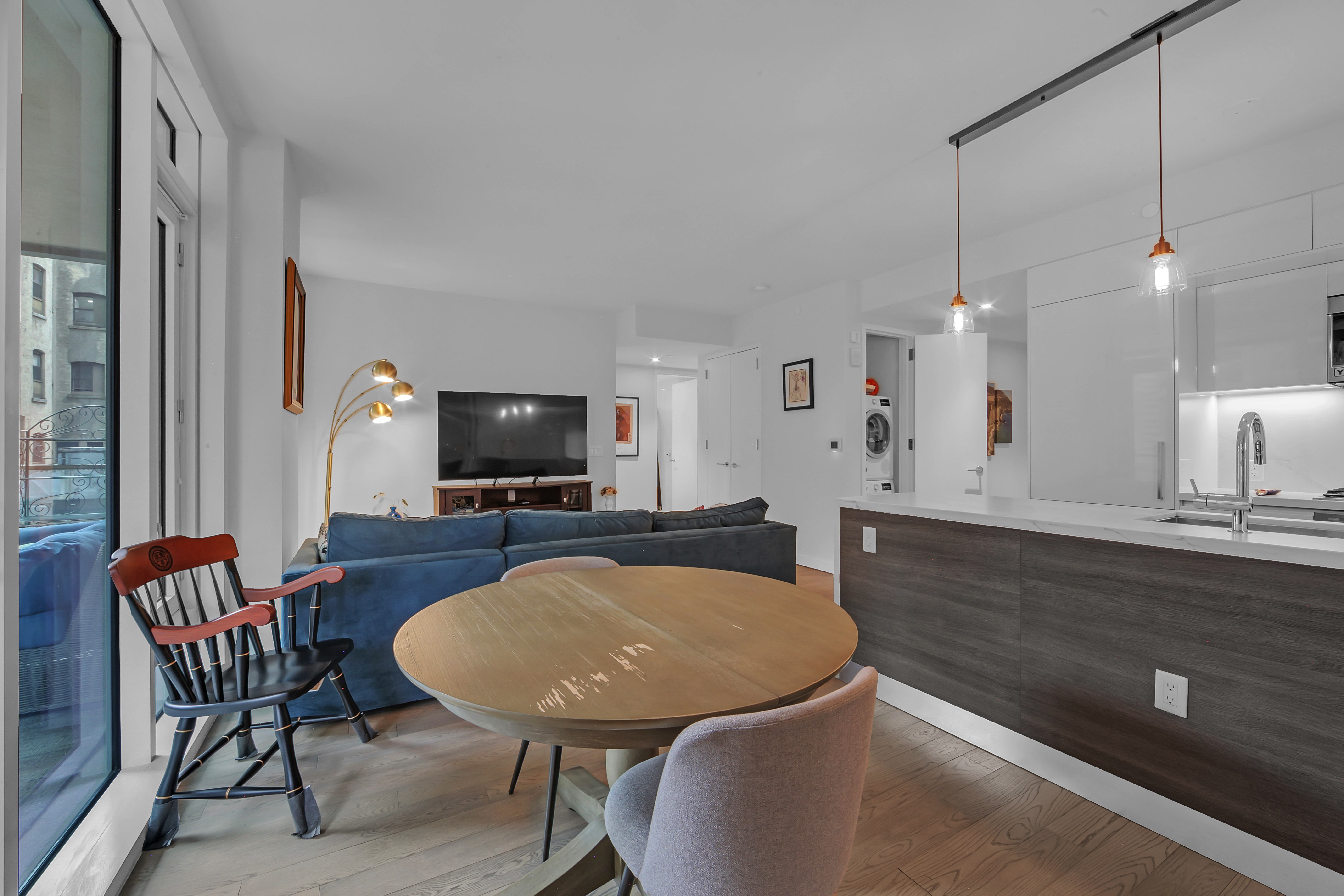 505-513 West 43rd Street, Unit 3M Manhattan, NY 10036 - Photo 5 of 20 a living room with furniture a flat screen tv and kitchen view