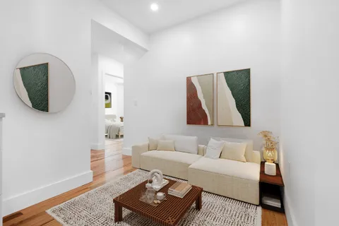 a living room with furniture and a wooden floor