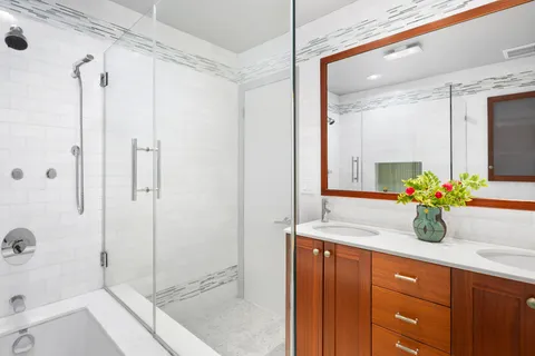 a bathroom with a granite countertop sink mirror and shower