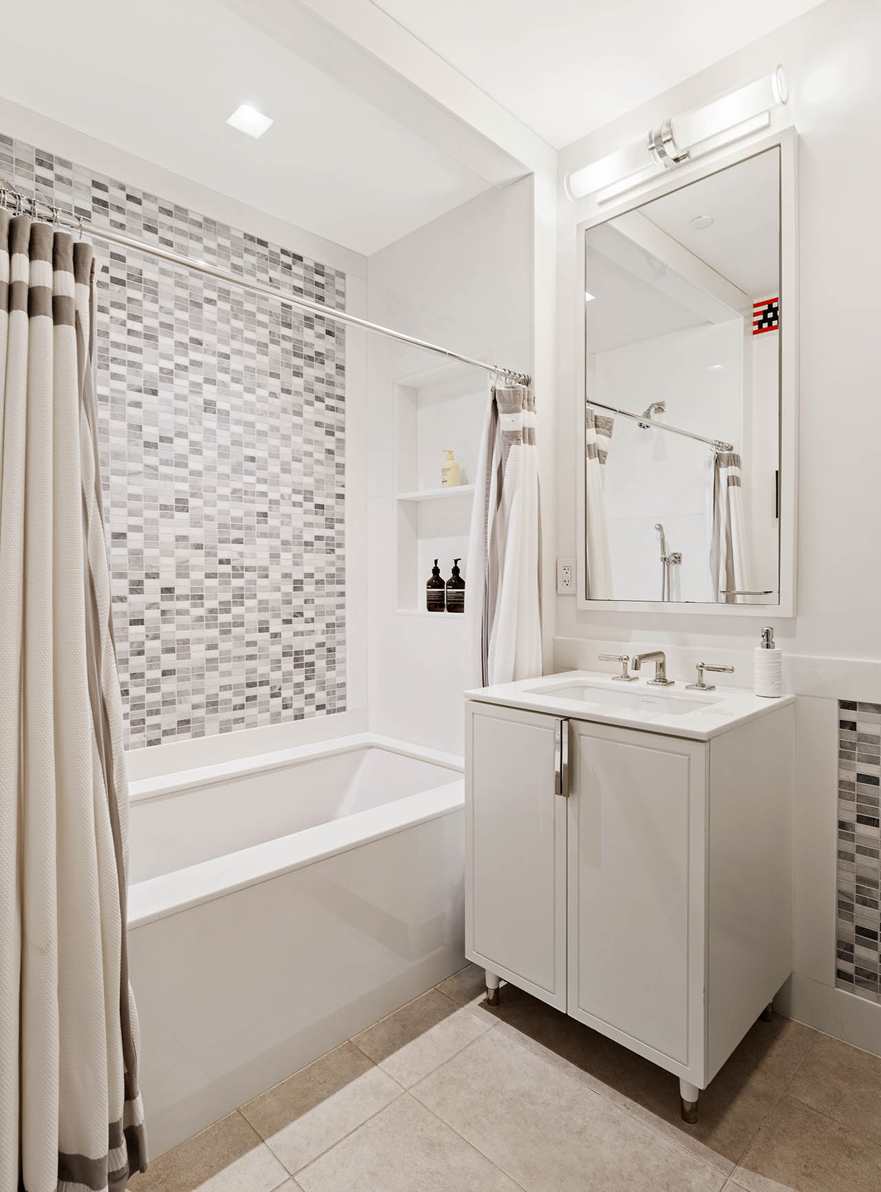 212 5th Avenue, Unit 9B Manhattan, NY 10010 - Photo 12 of 16 a bathroom with a bathtub sink and mirror