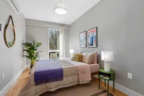 a bedroom with a bed lamps and a mirror