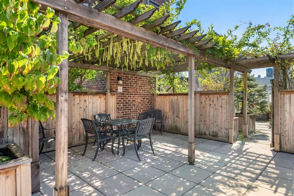 a patio with table and chairs and potted plants