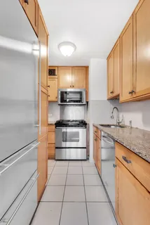 a kitchen with stainless steel appliances granite countertop a refrigerator and a stove top oven