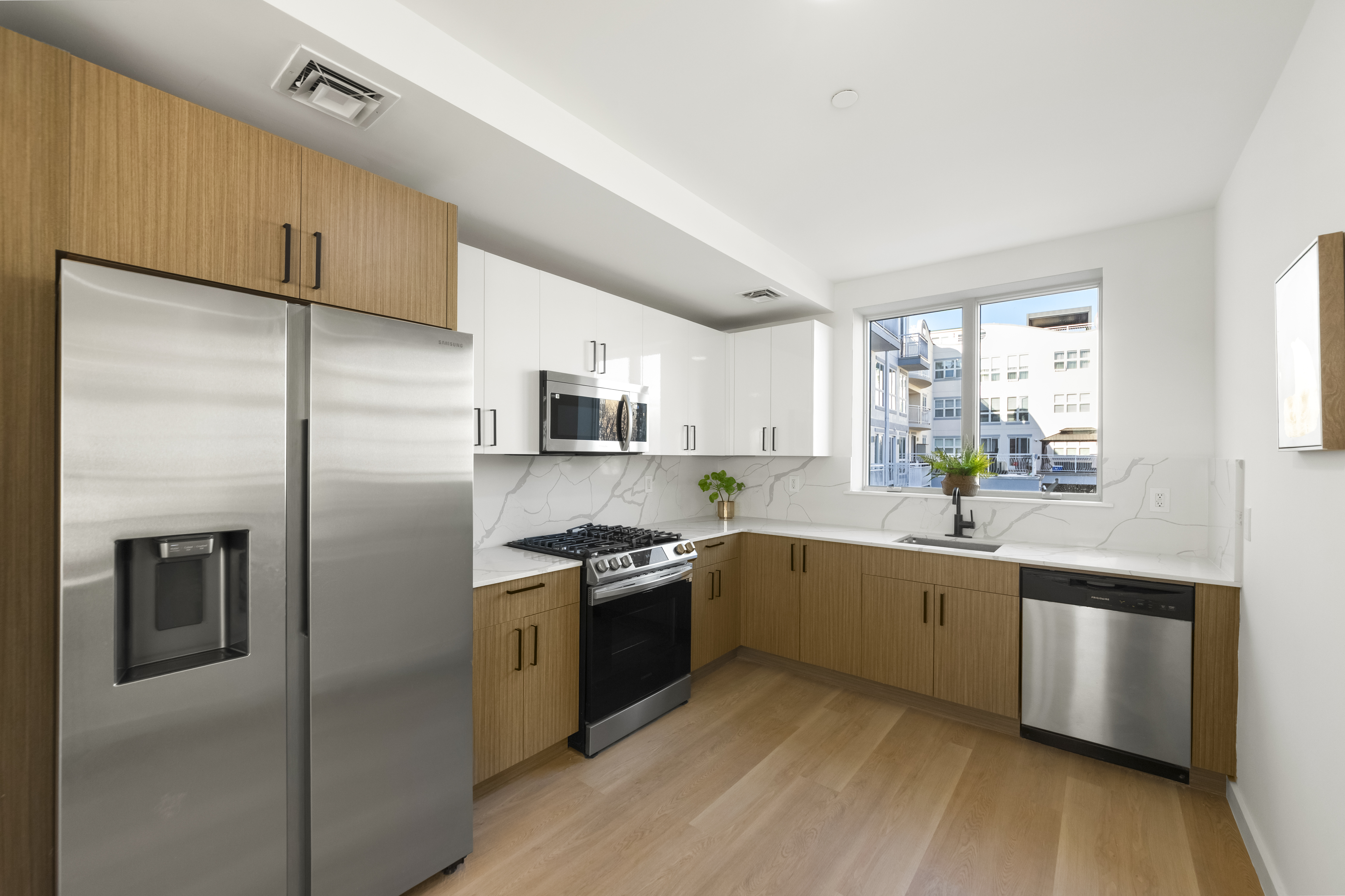 3112 Emmons Avenue, Unit 3132-2 Brooklyn, NY 11235 - Photo 2 of 11 a large kitchen with stainless steel appliances granite countertop a stove a sink and a refrigerator