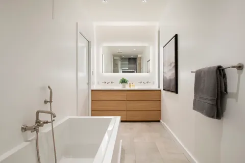 a bathroom with a tub sink and mirror