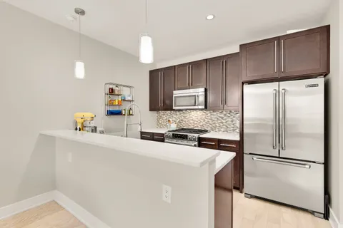 a kitchen with a refrigerator a stove top oven a sink and cabinets