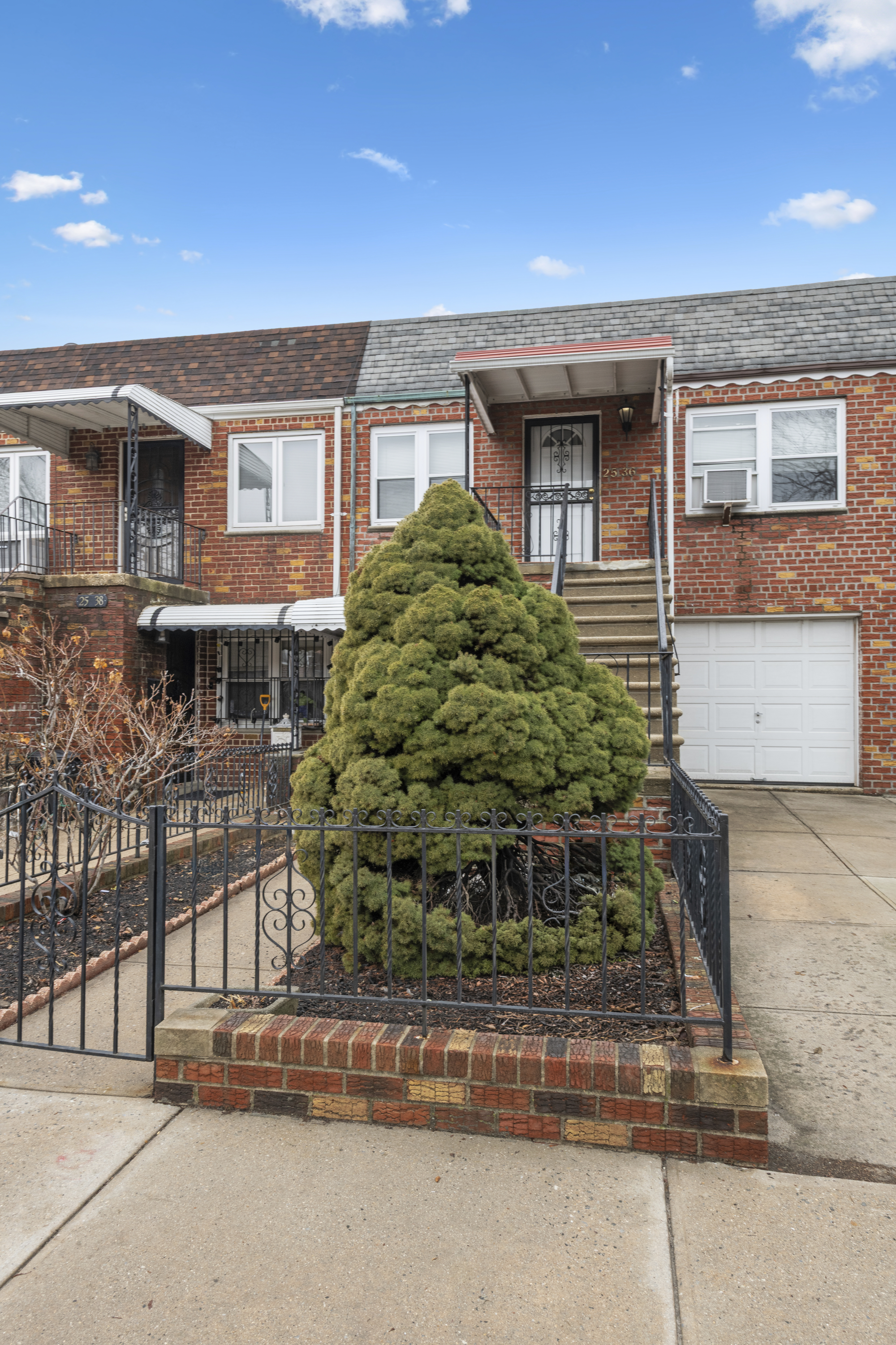 25-36 72nd Street Queens, NY 11370 - Photo 15 of 17 front view of a house and a yard