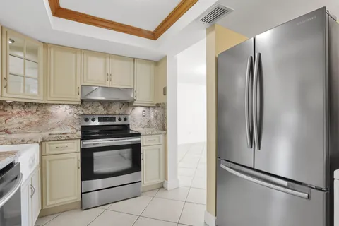 a kitchen with stainless steel appliances granite countertop a refrigerator and a stove top oven