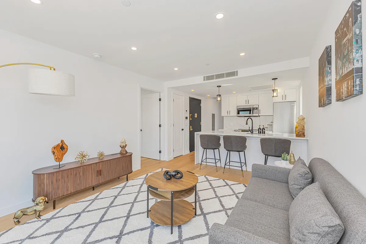 21-10 31st Avenue, Unit 6R Queens, NY 11106 - Photo 8 of 17 a living room with furniture and kitchen view