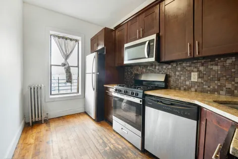 a kitchen with stainless steel appliances granite countertop a stove a sink and a microwave